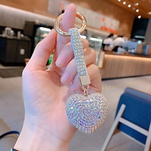 Close-up of a sparkling rhinestone heart keychain held in hand to show scale