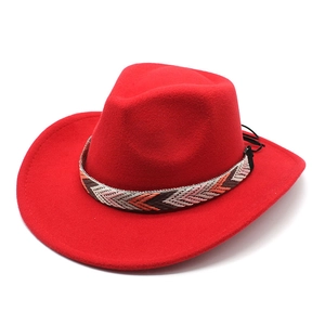Détail chapeau de cowboy rouge avec ruban ethnique tissé et bord incurvé