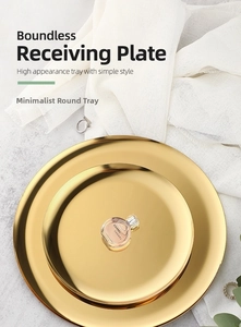 Detail view of two golden stainless steel round trays with elegant polished finish