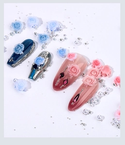 Nail art detail showing 3D blue and pink resin roses with silver and white pearls