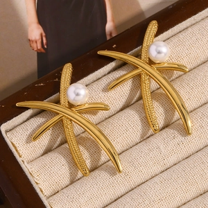 Crossed 18K gold plated stainless steel pearl earrings on a beige display box