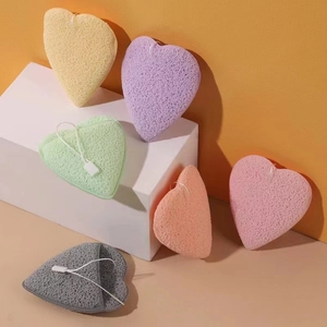 Heart-shaped facial cleansing sponges in six colors on white geometric stands
