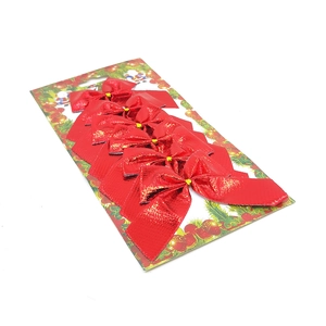 Close-up of red glitter Christmas bows organized on a festive card packaging