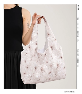 Detail of floral print canvas tote bag featuring large capacity and stylish beige design