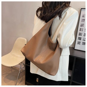 Brown leather large capacity tote bag shown on model wearing white blazer
