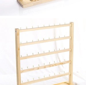 Detail of multi-tier wooden earring display stand with six rows of metal hooks for jewelry