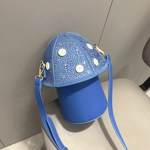 Close-up of mushroom-shaped blue leather handbag with sparkling rhinestones and white dots