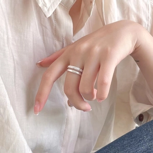 Minimalist double-layered silver ring set with hammered texture worn by a model