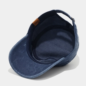 Detailed side view of washed cotton cadet cap featuring mountain leather patch and metal buckle