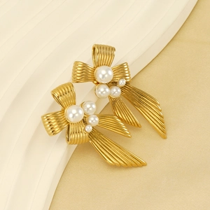 French vintage gold bow earrings with pearls on silk fabric background