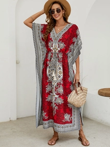 Detail of red Bohemian kaftan featuring ethnic patterns, V-neck, and cinched waist design