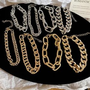 Set of gold and silver chunky chain bracelets with Cuban links on a white background