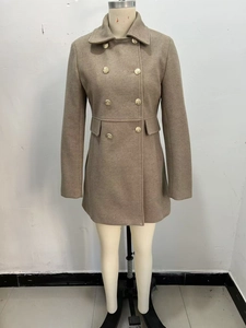 Close-up of golden metal buttons on khaki double-breasted wool blend coat for women