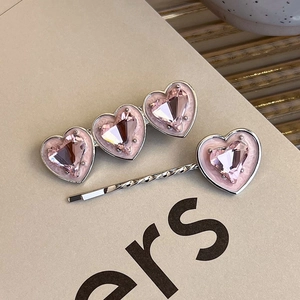 Detailed macro view of silver alloy hair clips with faceted pink crystal hearts