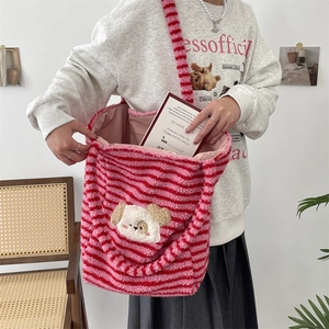 Detailed view showing large capacity of striped plush dog tote bag being filled with books