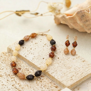 Detailed view of acrylic beaded necklace and earrings set with marble texture on stone
