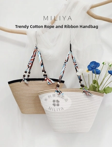 Detail of woven cotton tote bags with geometric ribbon handles and wooden bead accents