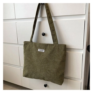 Detail of dark green corduroy tote bag showing ribbed texture and Fashion label