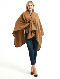 Brown knitted poncho with black leather piping and cross strap closure detail