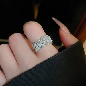 Detail showing multilayer silver ring with white pearls and sparkling rhinestones