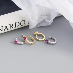 Detail of S925 silver hoop earrings with red floral zircon stones and pavé diamonds