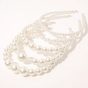 Detail showing multiple elegant white pearl headbands with varying sizes and textures