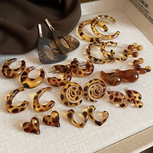 Flat lay of vintage leopard print resin earrings in tortoiseshell hoop and geometric styles