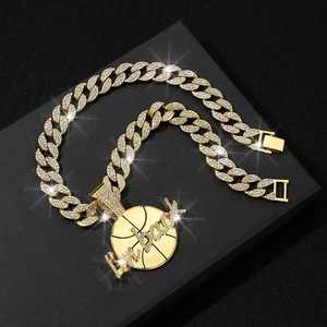 Detail of gold Cuban link chain with iced out basketball pendant engraved with I'm back