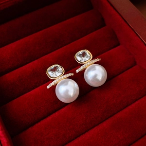 Elegant gold pearl earrings with square zircons displayed in a red velvet jewelry box