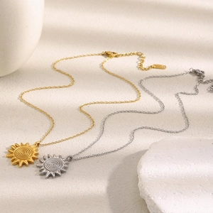 Detailed shot of sun pendant necklaces with spiral patterns in gold and silver finish