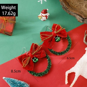 Christmas wreath earrings with red bows and green bells on festive holiday background