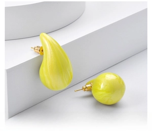 Detailed view of yellow marble textured teardrop and sphere stud earrings for women