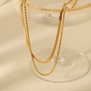 Layered gold stainless steel snake and twist chains displayed on a glass tray