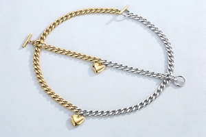 Close-up of gold and silver mixed Cuban chain necklace with heart charms and OT toggle clasp