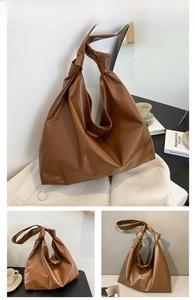 Detail of a brown leather tote bag showing a knotted strap and soft hobo style texture