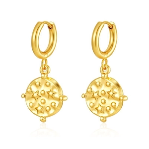 Close-up of gold stainless steel hoop earrings with star and dot pattern on white backdrop