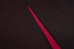 Detailed close-up of dark red knit dress showing vertical texture and lining contrast