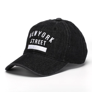Detailed close-up of NEW YORK STREET white embroidery on black washed denim baseball cap