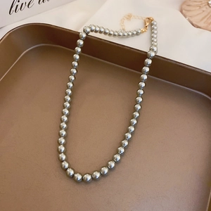 French retro grey pearl necklace with gold-plated lobster clasp in a bronze tray