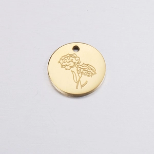 Detailed view of a gold circular birthday flower pendant with delicate floral engraving