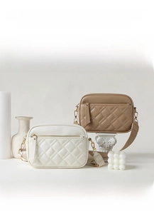 Detail of quilted top-grain leather crossbody bags with adjustable wide straps and zippers