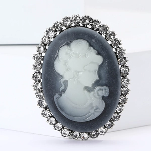Macro detail of elegant cameo brooch with white portrait profile and sparkling rhinestones