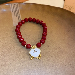 Détail du bracelet en perles de cinabre rouge avec pendentif Ruyi blanc et grelots