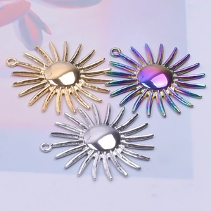 Detailed view of sun-shaped stainless steel pendants in gold, silver and rainbow finish