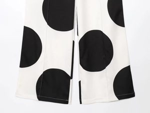 Detalle de pantalones anchos de lunares blancos y negros con textura tejida y dobladillo liso