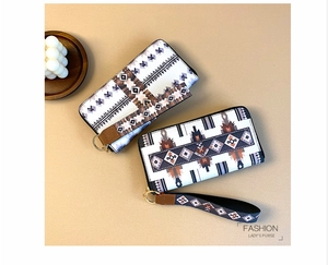 Detail view of ethnic geometric pattern on long wallets with zipper and wrist strap