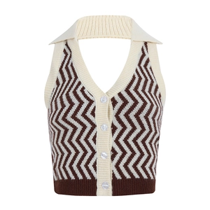 Dettaglio del top a v con motivo chevron in maglia, scollo a v e bottoni bianchi