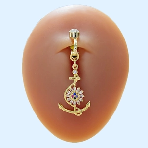 Piercing de nombril ancre dorée avec zircons colorés sur un fond bleu clair doux