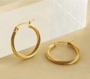 Detail shot of 18K gold-plated stainless steel twisted rope hoop earrings on acrylic
