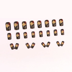 Press-on nails in black and red with gold floral patterns in square-round shape